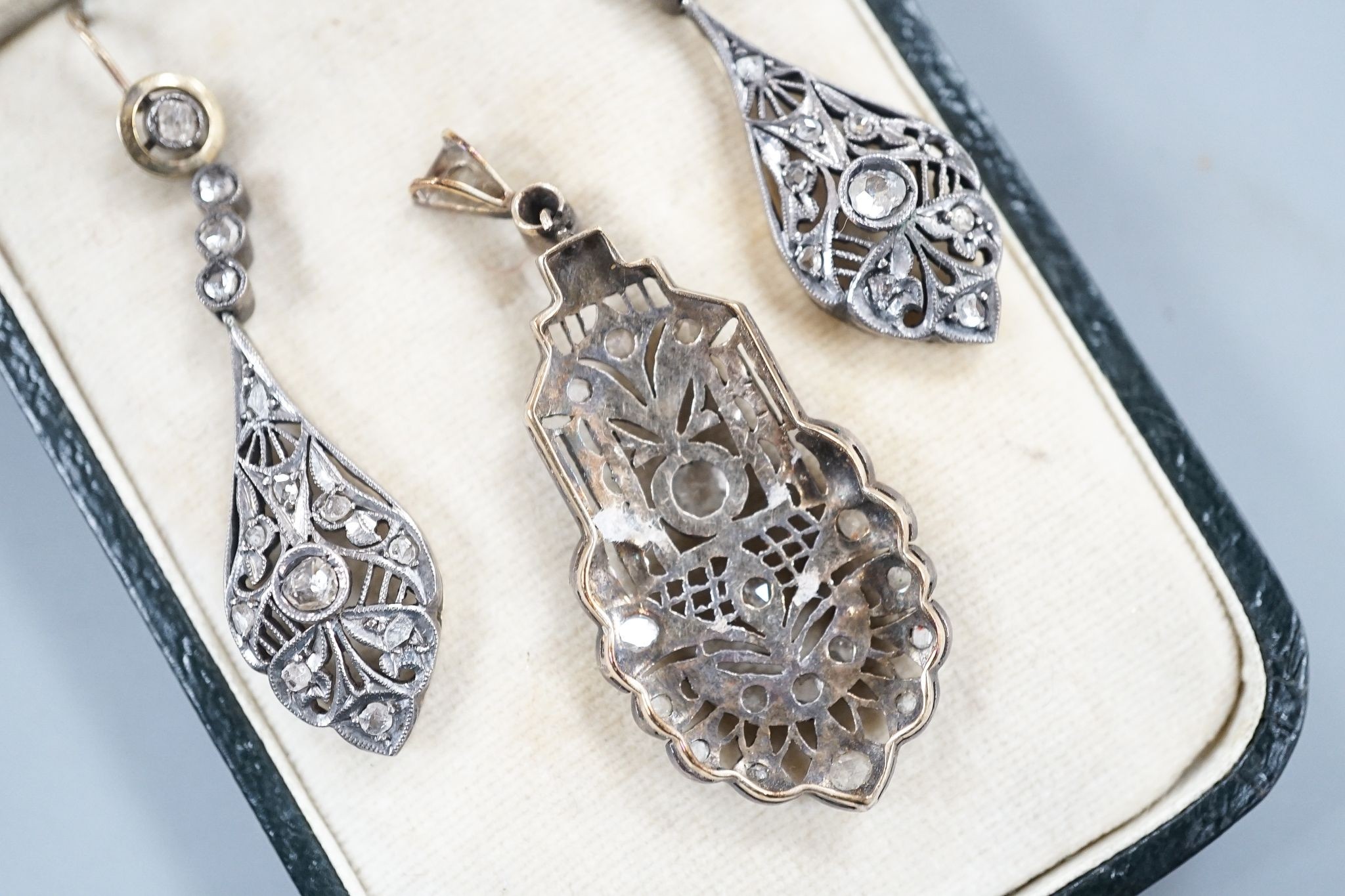 A 19th century pierced white and yellow metal and rose cut diamond set suite of jewellery, comprising a pendant 48mm and a pair of matching drop earrings, gross weight 11.2 grams.